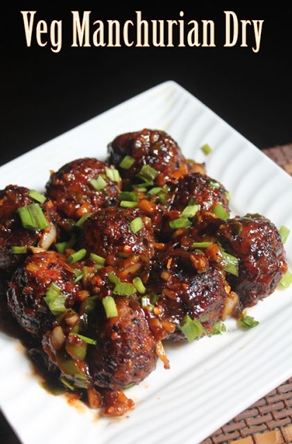 a white plate topped with meat covered in sauce and green onions on top of it