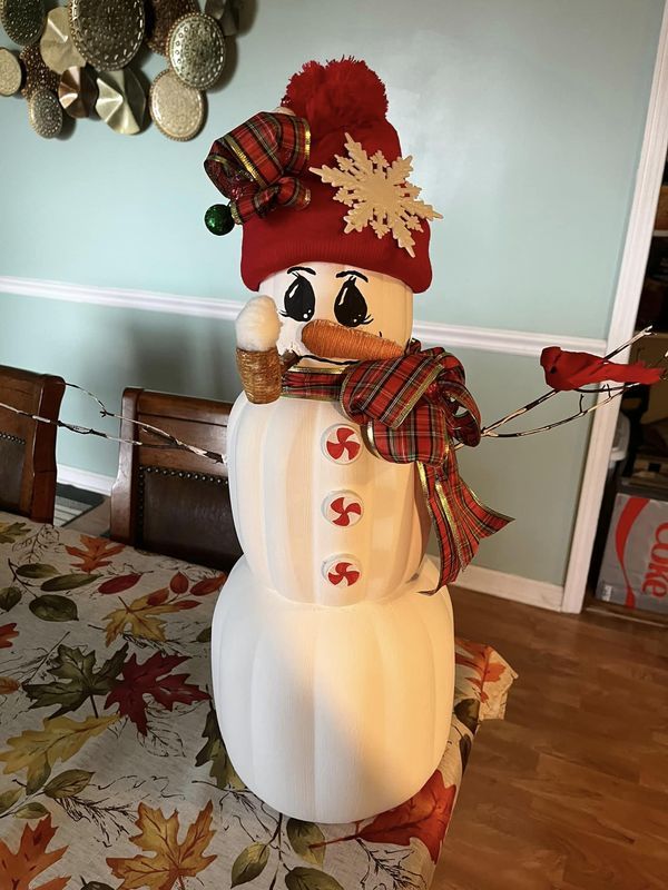 a lighted snowman with a red hat and scarf