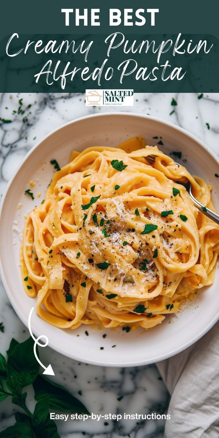 the best creamy pumpkin alfredo pasta with parmesan cheese and herbs in a white bowl