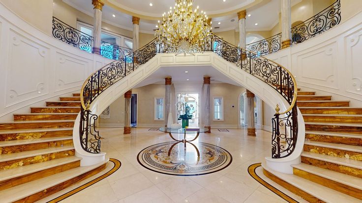 an ornate staircase with chandelier and marble floors