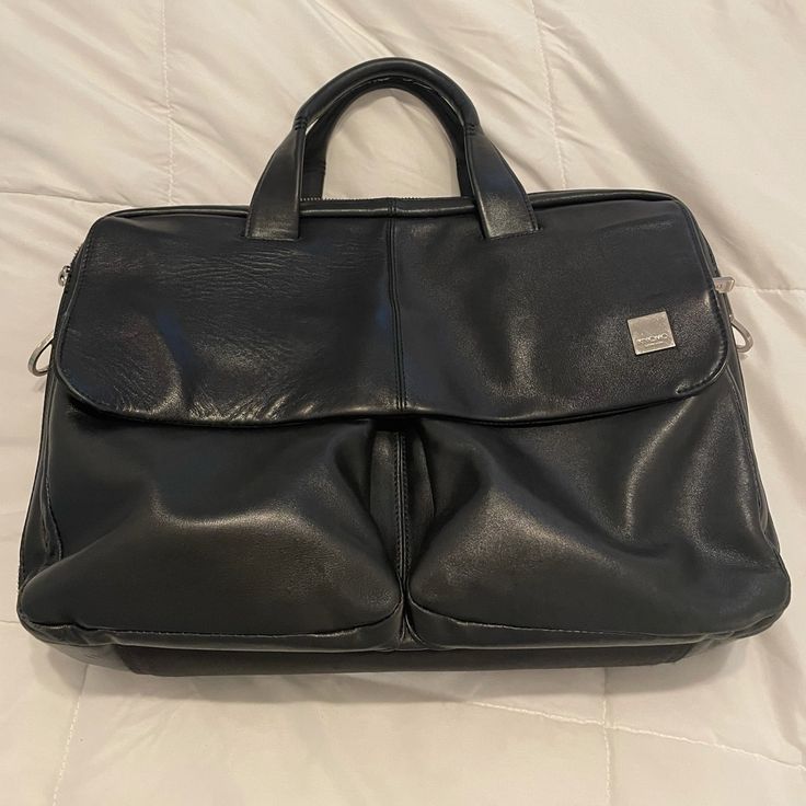 This Is A Used Knomo London Warwick Black Leather Messenger Bag. The Flap That Covers The Two Front Pockets Has A Magnetic Closer, And There Are Multiple Internal Pouches And Zip Pockets To Organize All Of Your Essentials. Padded Main Compartment Fits Laptops Up To At Least 15.5 (I Have One). Besides Having A Few Minor Scuffs (They Do Not Show In Pictures) The Only Sign Of Wear Is On The Handles. Some Of The Outer Layer Of Stitching Has Loosened. The Inner Stitching Is Still Intact. No Strap. Black Bags For Business Trips With Detachable Strap, Soft Leather Tote For Business Trips, Soft Leather Tote Bag For Business Trips, Black Soft Leather Bags For Business Trips, Black Leather Briefcase With Double Handle, Black Tote Satchel For Business Trips, Black Double Handle Shoulder Bag For Business Trips, Black Shoulder Bag With Detachable Strap For Business Trips, Black Satchel Bag For Business Trips