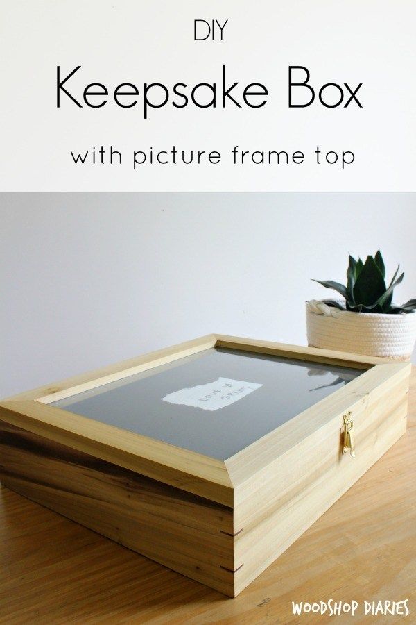 a wooden box sitting on top of a hard wood floor next to a potted plant