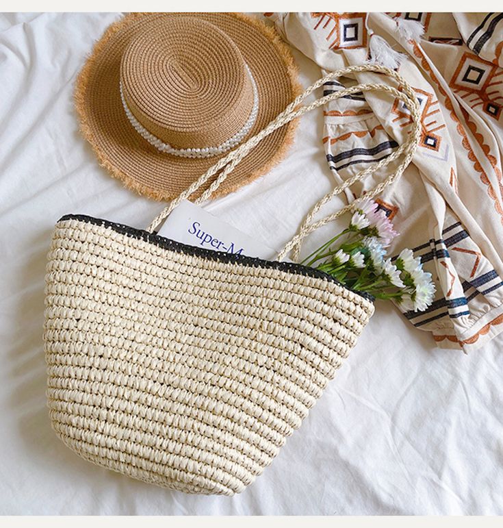 a straw bag and hat laying on a bed