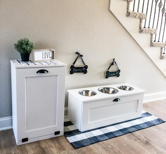 a dog house with two dogs in it next to a stair case and a rug