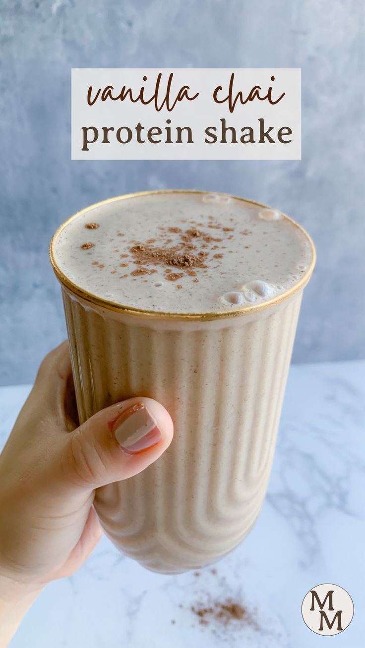 a hand holding a cup filled with vanilla chai protein shake