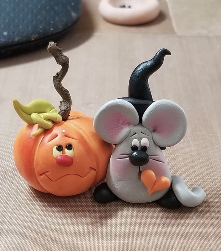 two figurines sitting on top of each other in the shape of pumpkins