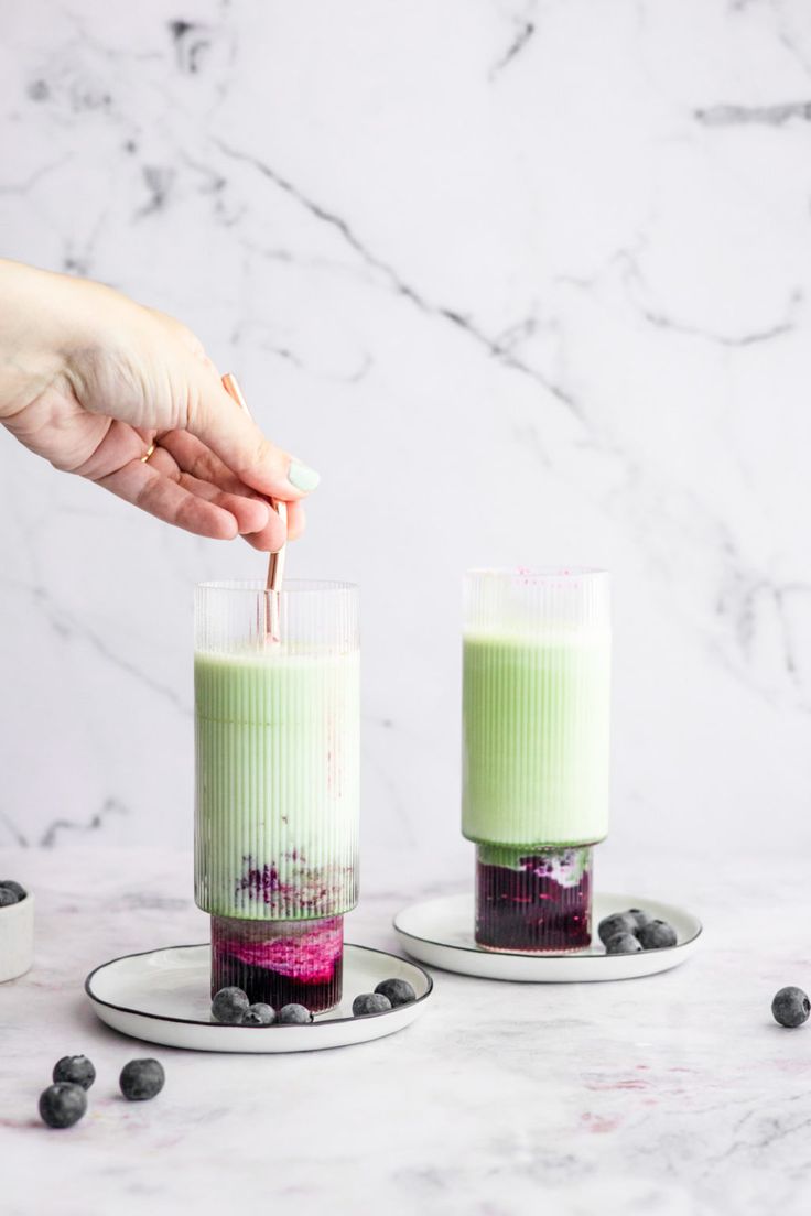 two small jars filled with green liquid and blueberries