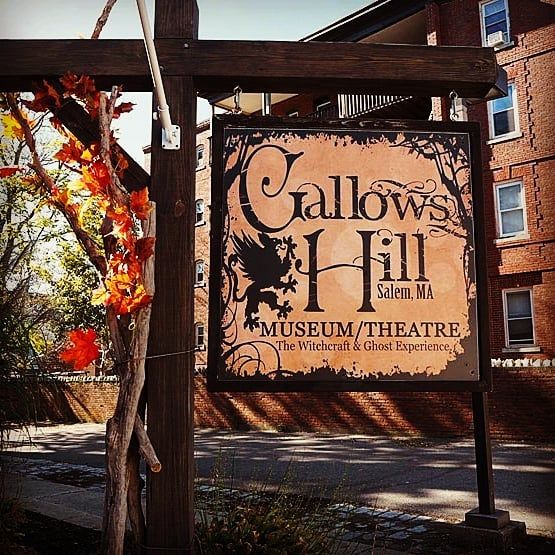 a sign for the gallops hill museum and theatre in front of a brick building