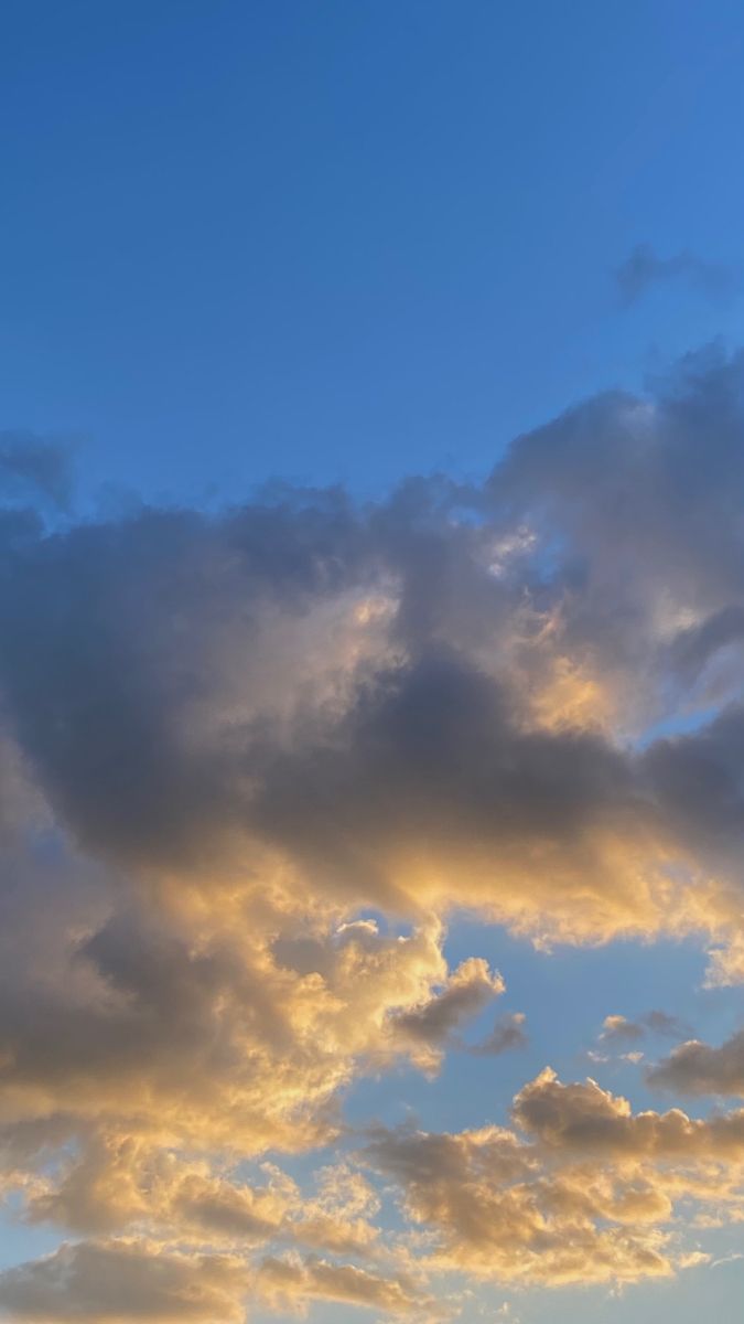 the airplane is flying high in the sky at sunset or dawn, with some clouds above it