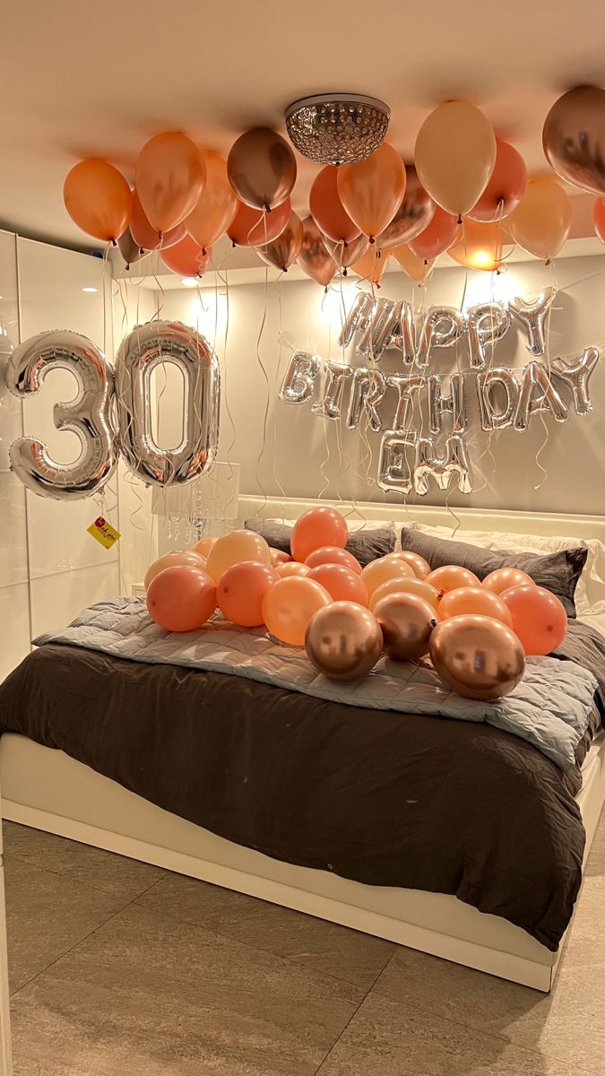 a bedroom decorated with balloons and streamers in the shape of numbers for 30th birthday