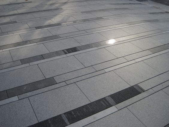 the sun shines through the window on an empty brick sidewalk in front of a building