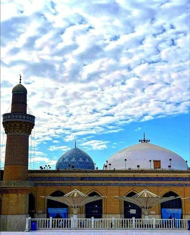 an image of a building that is in the middle of the day with clouds above it