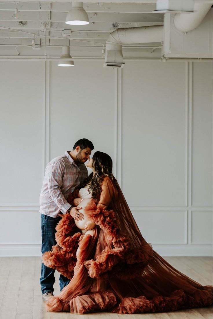 a man and woman standing next to each other in an empty room