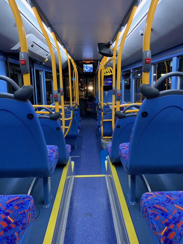 the inside of a bus with blue and yellow seats