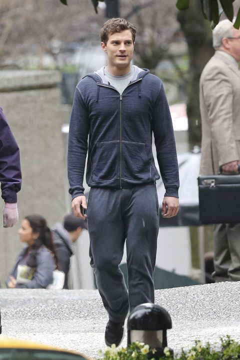 a young man walking down the street in his tracksuits, with other people behind him