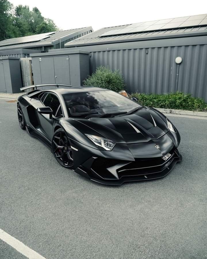 a black sports car parked in front of a building