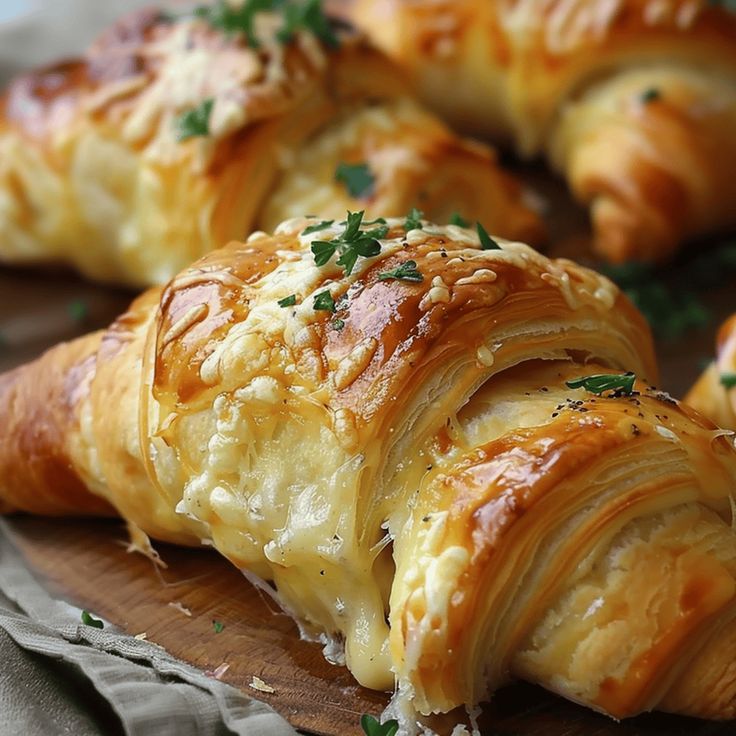 several croissants with cheese and parsley on top