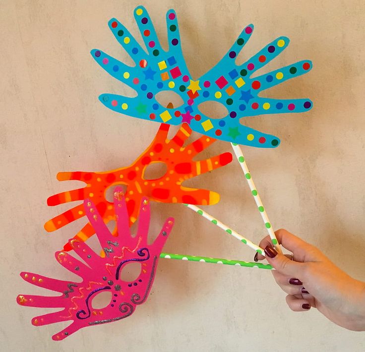 a person is holding up some colorful hand puppets on the wall with polka dot designs