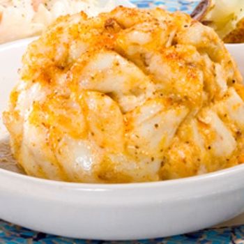 some food is in a white bowl on a blue and white table cloth next to other foods