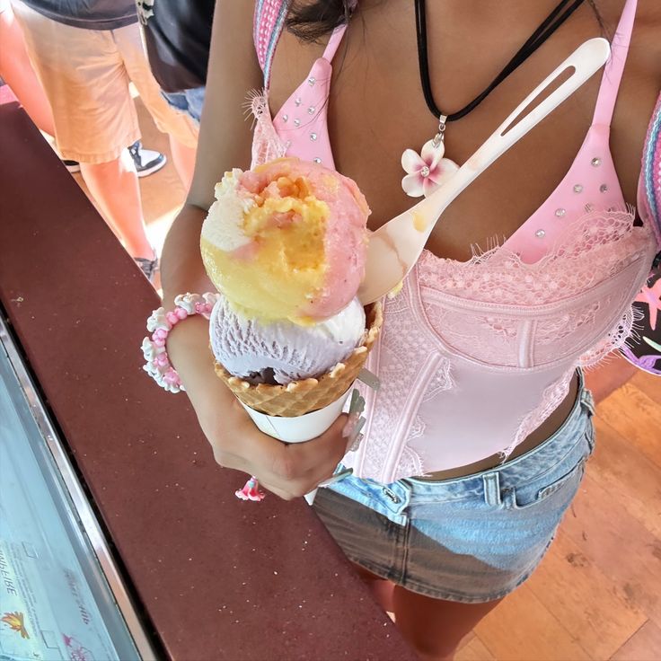 a woman holding an ice cream cone in her hand