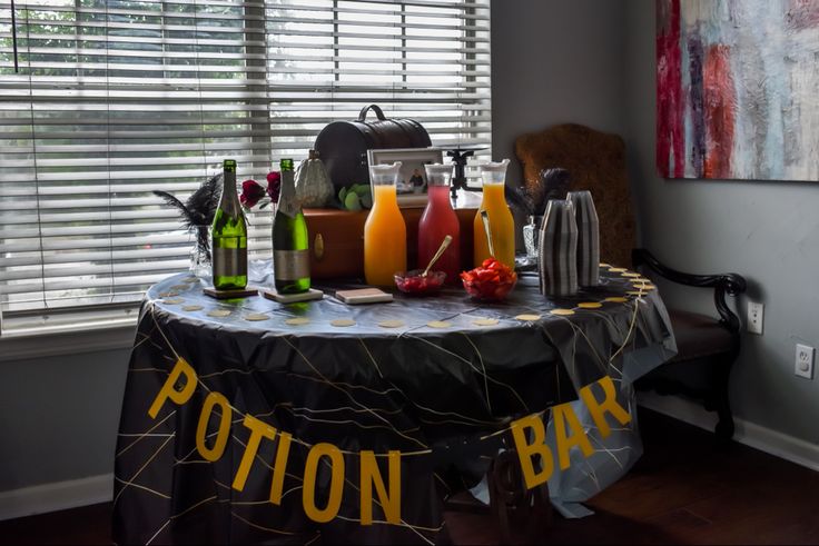 a table topped with lots of bottles of juice and condiments next to a window