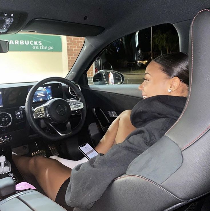 a woman sitting in the driver's seat of a car