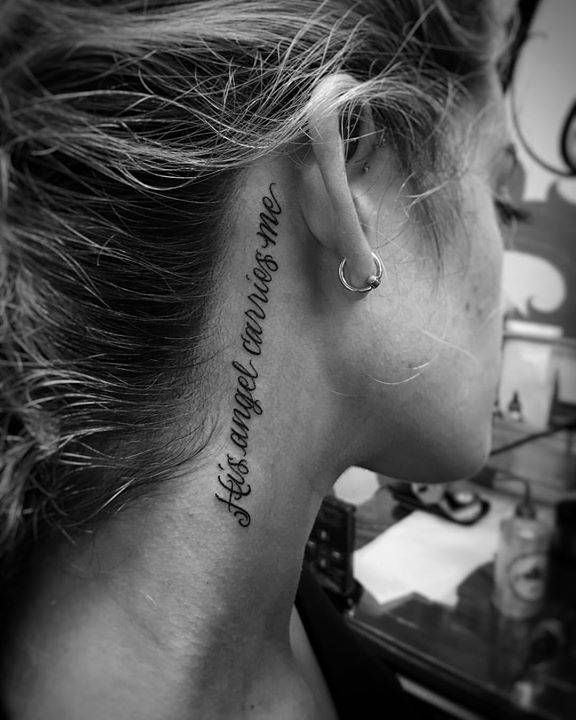 a woman with a tattoo on her neck that says, she is the only one who can