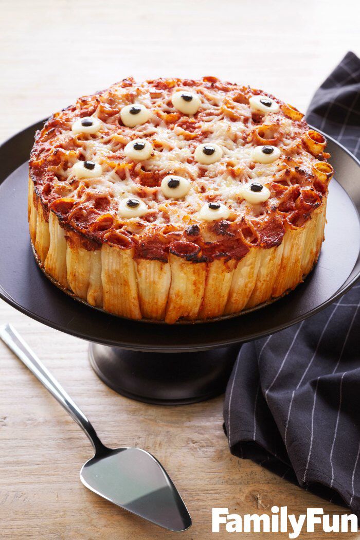 a pizza sitting on top of a black plate next to a spatula and spoon