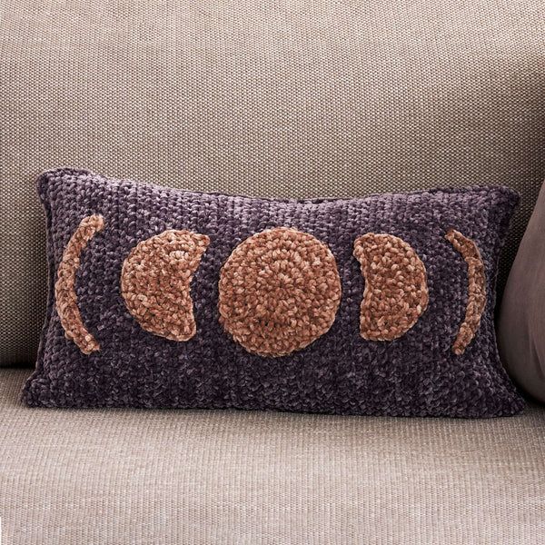 a couch with a pillow on it that has three circles in the middle and four dots at the bottom