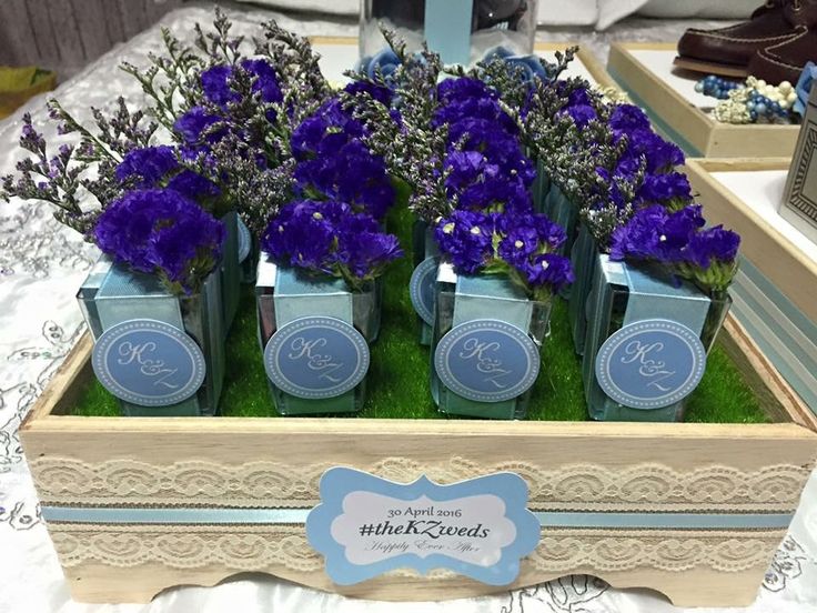 purple flowers are in small blue vases on a table