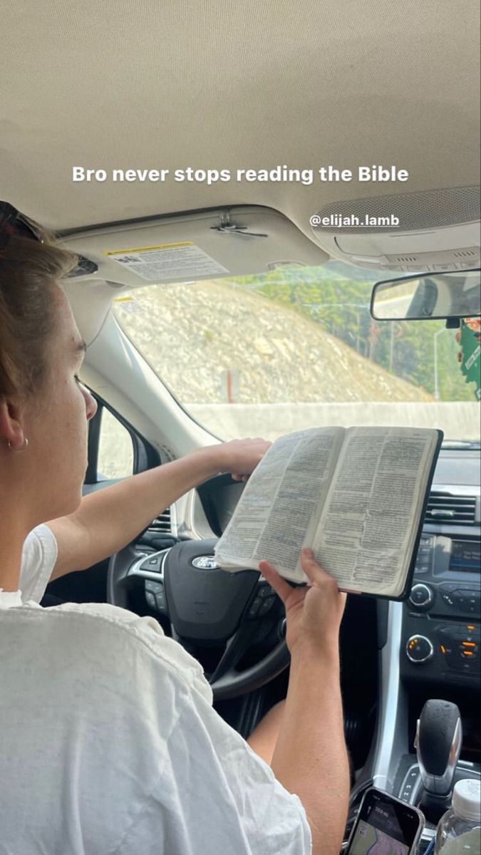 a woman driving a car while holding an open bible in her hand with the words bro never stops reading the bible