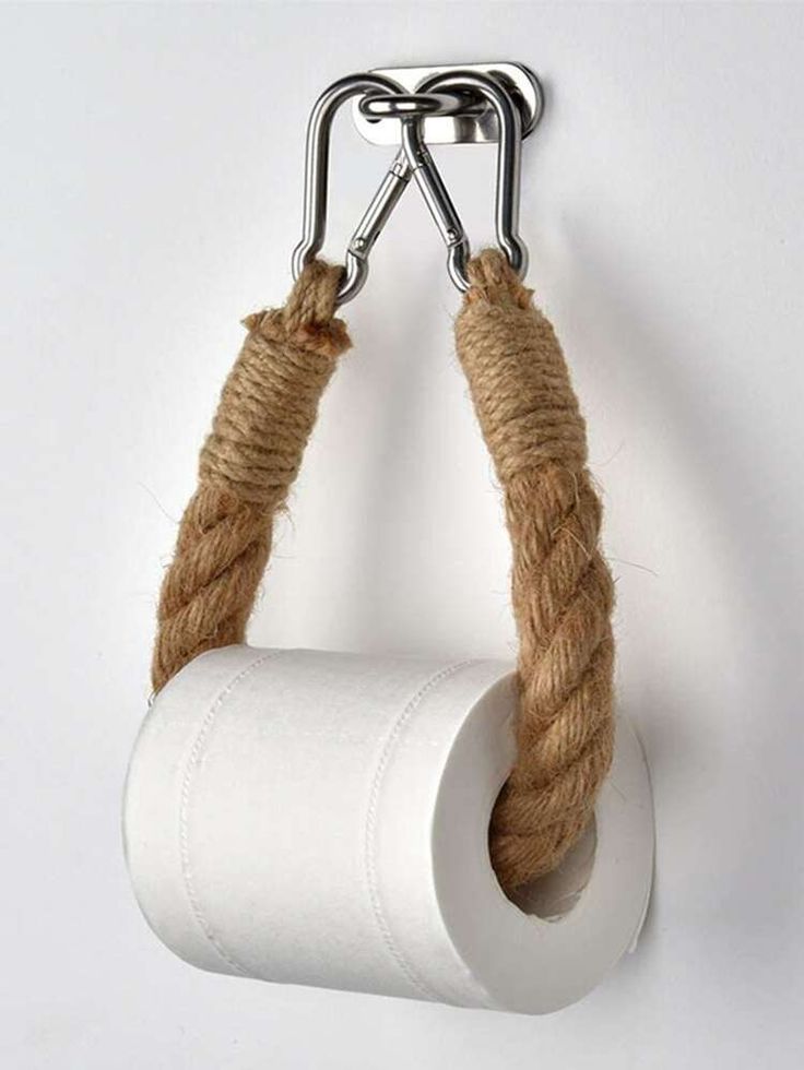 a roll of toilet paper hanging from a metal hook on a wall with rope wrapped around it