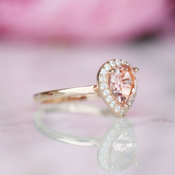 Beautiful Pear Peachy-Pink Morganite Stacking Ring Set ►Base Metal: Sterling Silver (S925) ►Plating: 14K Rose Gold Vermeil ►Accented With Simulated Diamonds ►Please be aware that plated jewelry can wear off over time, if this is a concern we would suggest going with the sterling silver or solid gold jewelry option. Center Stone: Morganite Stone Cut: Teardrop Color: Peachy-Pink Stone size: 8.0 x 6.0 mm Carat Weight: 1.21 ct. Gemstone Creation: Lab-Created ►Sterling silver ring can be purchased at Classic Pink Cluster Ring For Anniversary, Pear Shaped Halo Wedding Rings, Rose Gold Teardrop Wedding Ring With Prong Setting, Pear-shaped Diamond Ring With Center Stone For Anniversary, Classic 14k Rose Gold Rings With Accent Stones, Classic Pear-shaped Diamond Ring For Anniversary, Pear-shaped Halo Design Wedding Ring, Pear-shaped Halo Wedding Ring, Teardrop Halo Setting Ring For Proposal