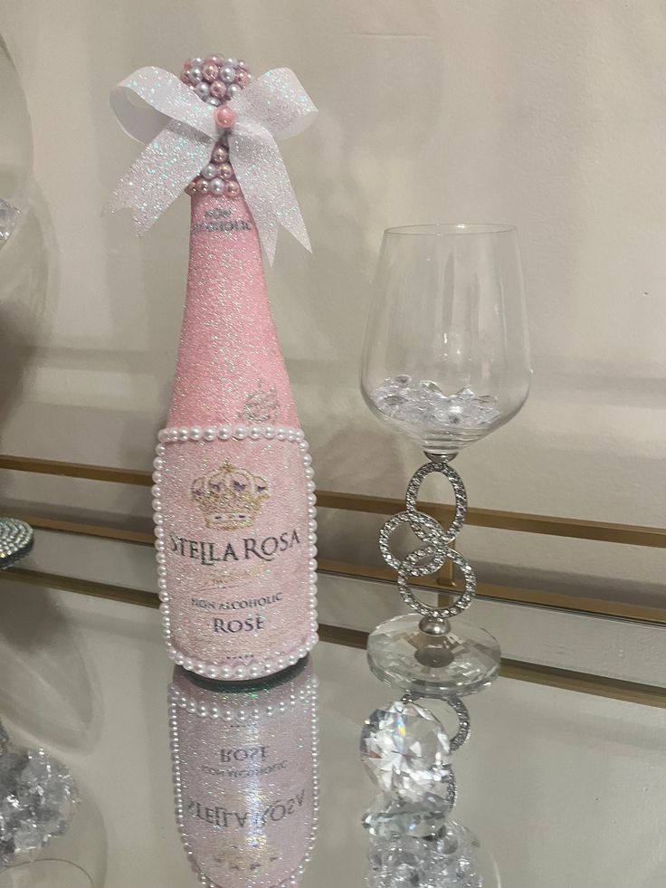 a bottle of pink wine sitting on top of a table next to crystal goblets