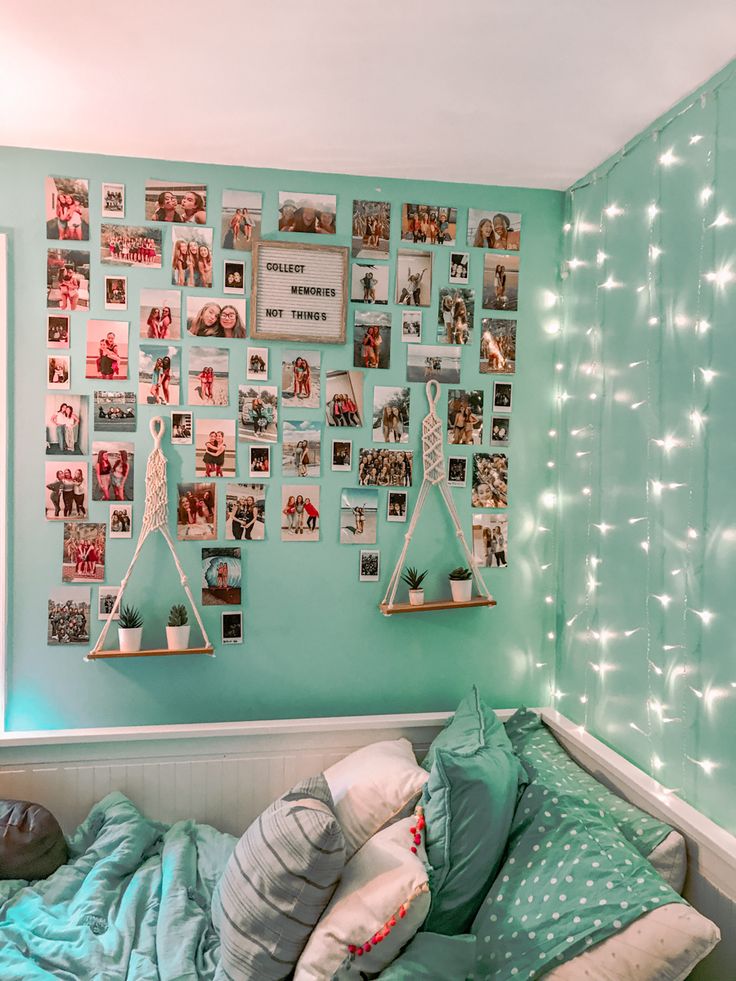 a bedroom with blue walls and pictures on the wall above the bed, along with hanging lights