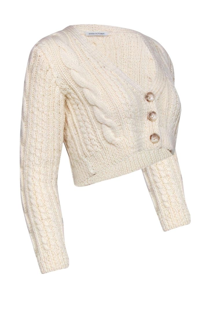 This Anna October Cream Cable Knit Crop Cardigan is one cozy way to spend a day indoors! Featuring a cream cable knit and a cropped fit, it's the perfect pick for a relaxing day of lounging at home. Pair this with knit pants for at home, or relaxed jeans for a day out! Size S 50% Fleece Wool, 50% Acrylic Dry Clean Only Unlined V-neckline Three button closure Crop length Cable knit Bust 34" Shoulder to hem 16.25" Sleeve length 23.25" Cozy Cable Knit Cropped Sweater In Winter White, Cozy Winter White Cable Knit Cropped Sweater, Cozy Fitted Cable Knit Cropped Sweater, Fitted Cozy Cable Knit Cropped Sweater, Fitted Cable Knit Cropped Sweater, White Cropped Cable Knit Sweater, Knit Crop Cardigan, Anna October, French Girl Chic