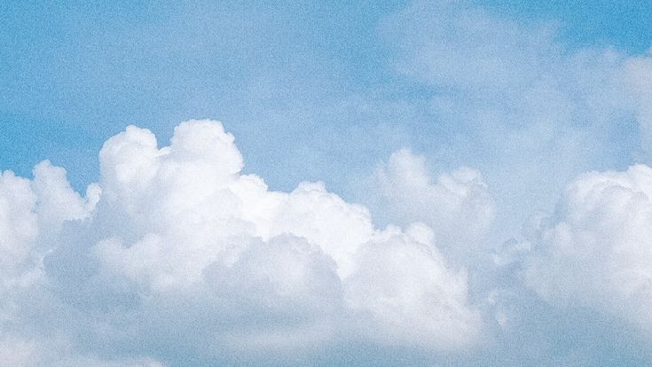 the airplane is flying high in the blue sky with white clouds above it and below