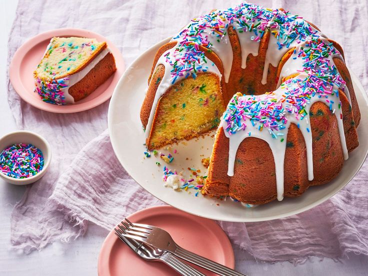 a bundt cake with white frosting and sprinkles on a plate