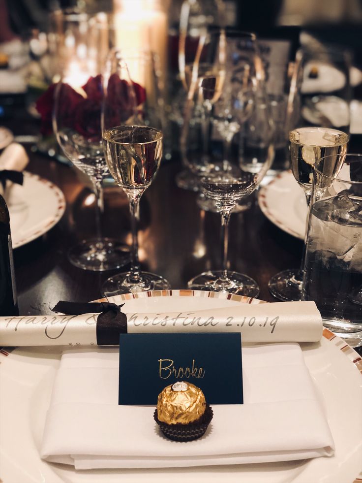 a table set with wine glasses, plates and silverware for an elegant dinner party