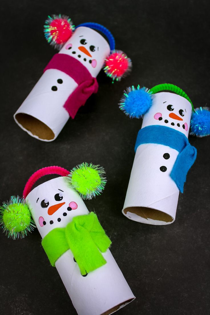 three snowmen made out of toilet paper tubes with pom - poms on them