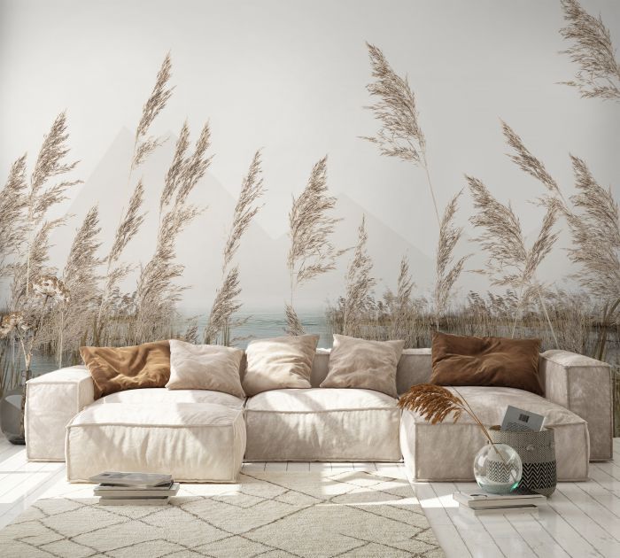 a couch sitting in front of a wall with plants on it and the ocean in the background