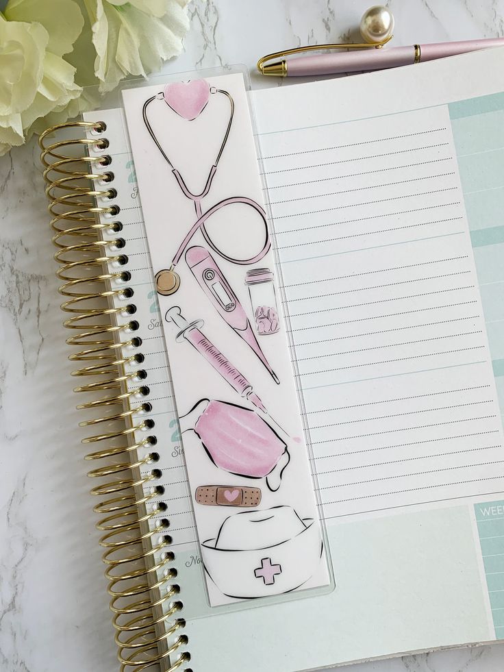 an open notebook with medical supplies on it next to a pen and flower arrangement in the background