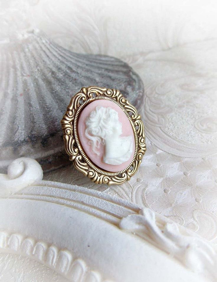 "A romantic vintage inspired ring featuring a cameo lady cabochon in aged brass ornate frame. The ring has an ornate ring band. Choose a color you like the most - light pink or ivory. Choose your size for a perfect fit so I can adjust it for your comfortable wear. The ring is safely riveted on the ring base that is opened, not closed. * The metal parts are of high quality brass * Nickel and lead free * Complimentary gift wrapped * Smoke free household Dimensions: * 1.38\" x 1.18\" (3,5 x 3 cm) * Ivory Ring, Antique Gold Rings, Ornate Ring, Vintage Inspired Rings, Bridesmaid Gifts Jewelry, Vintage Cameo, Cameo Ring, Ornate Frame, Bridesmaid Jewelry