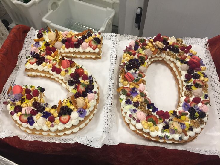 two decorated cookies are sitting on top of a white tablecloth with the number 50 spelled out