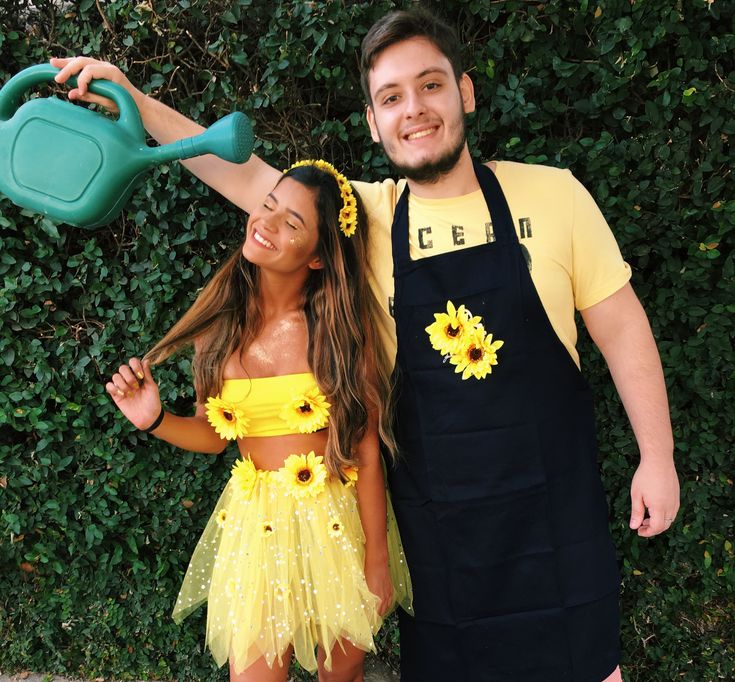 a man and woman dressed in costumes posing for a photo with sunflowers on them