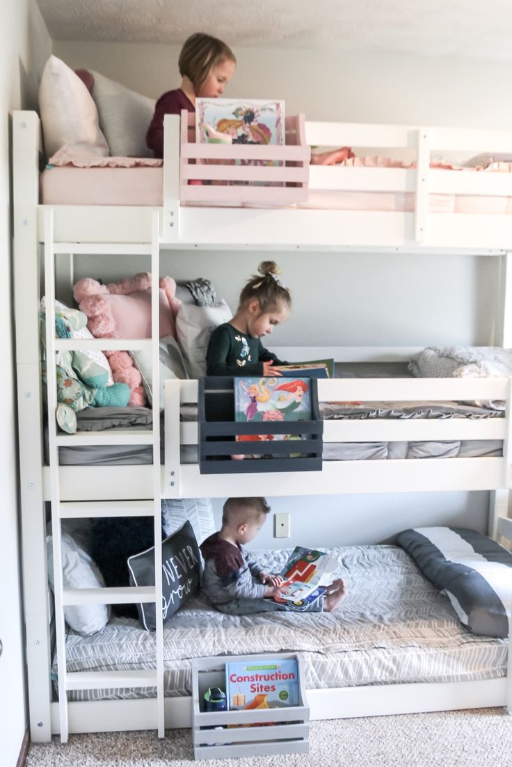 two children are sitting on bunk beds with books in their hands and one child is reading