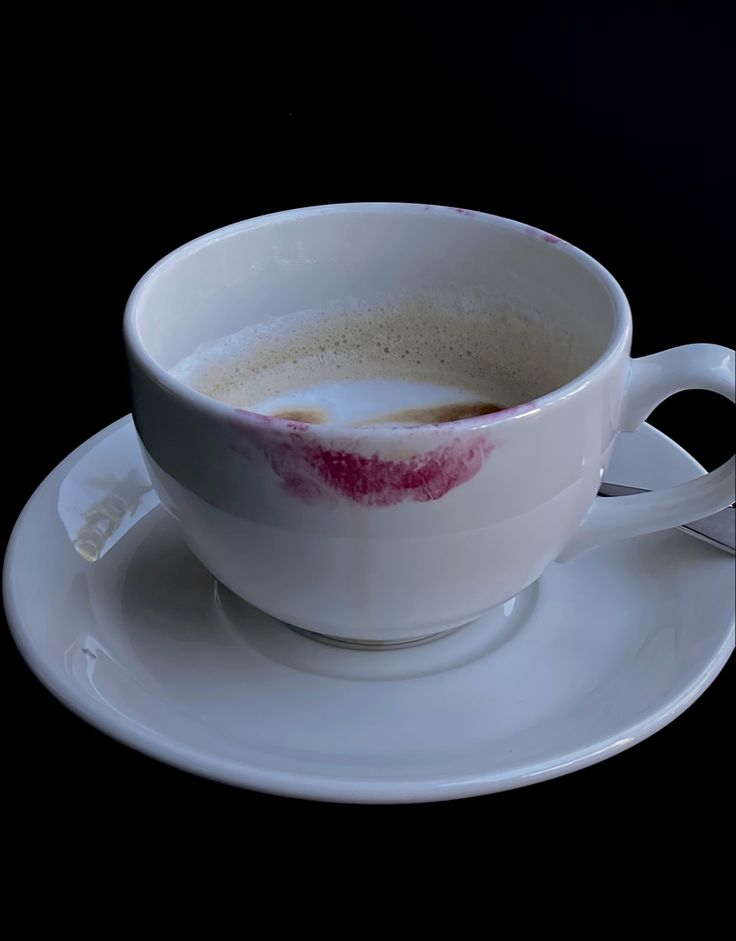 a white cup filled with liquid on top of a saucer