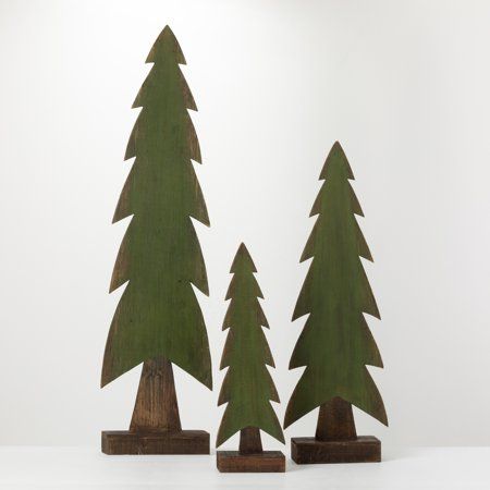 three wooden trees are standing in front of a white wall and one is made out of wood