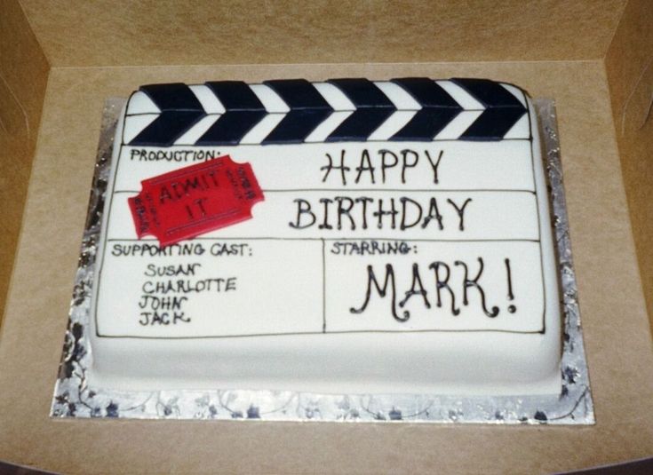 a birthday cake that is decorated like a movie clapper with the words happy birthday mark on it