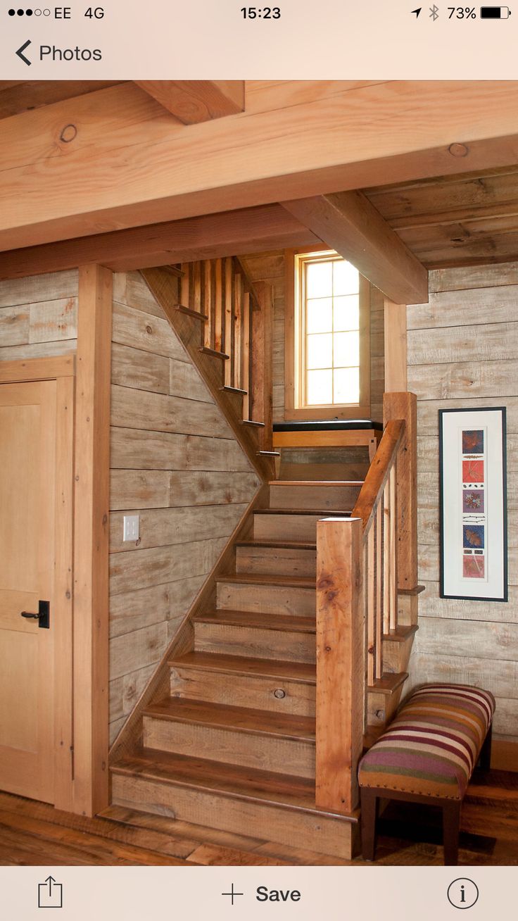 a wooden staircase leading up to the second floor in a home with wood floors and walls